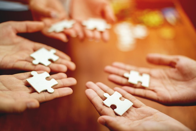 Concetto di unità e cooperazione del lavoro di squadra mano che tiene il puzzle del primo piano del pezzo di mano che collega il puzzle collegato l'un l'altro soluzione aziendale concetti e strategie di successo