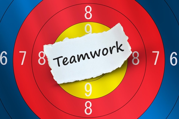 Teamwork word on white paper with arrow target board