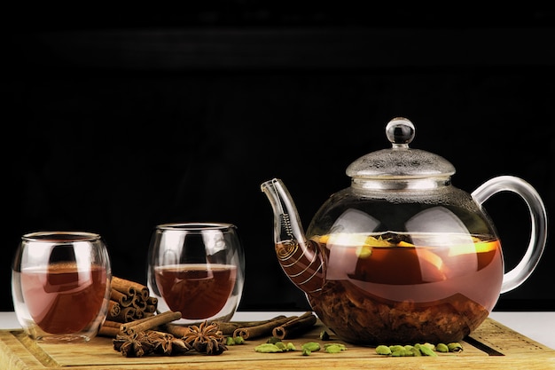 Фото Чайник и чашка чая на темном фоне