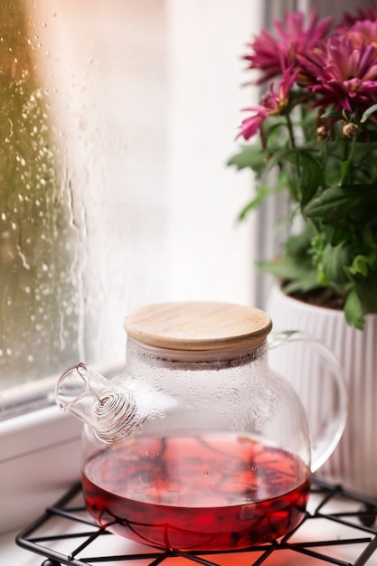 窓際の急須と秋の花雨の日