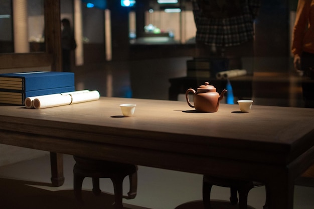 Teapot and books close up in dark room