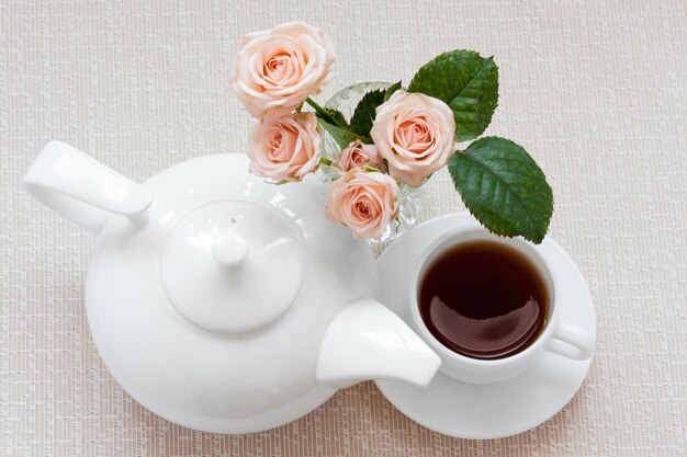 Teapot, cup, and roses on a plate