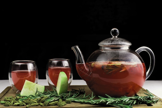 Teapot and cup of tea on a dark background