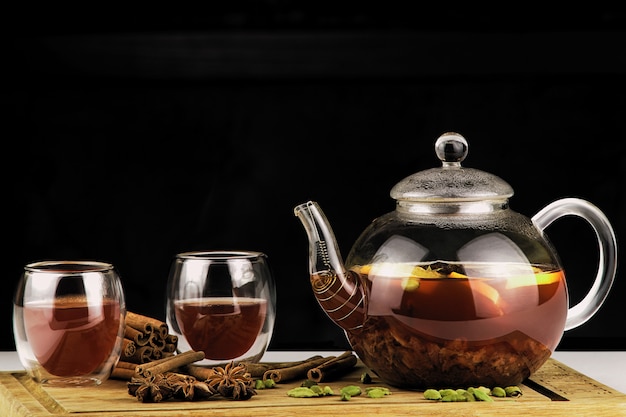 Teapot and cup of tea on a dark background