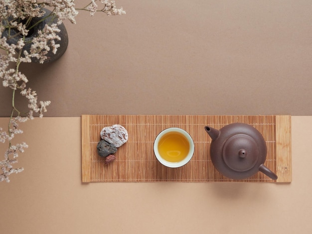 Teapot and cup of tea near stone