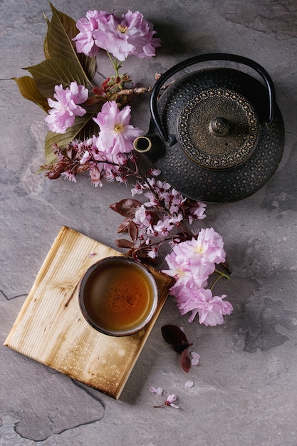 Teapot and cup of tea with blossom branch