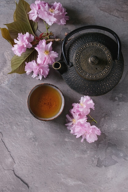 Teapot and cup of tea with blossom branch