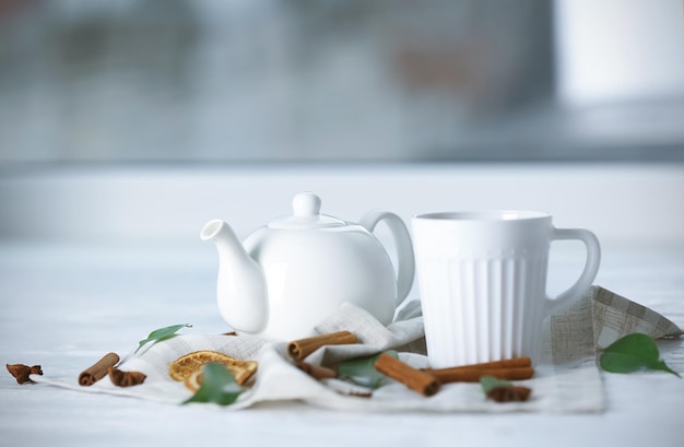 Teapot and cup with tea on wooden table