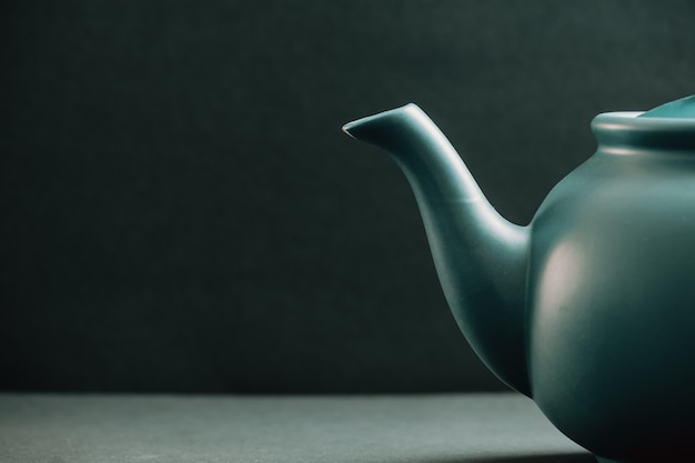 Teapot showing from the right corner over a dark background