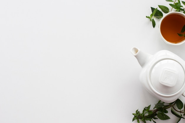 Teapot with cup of tea and mint