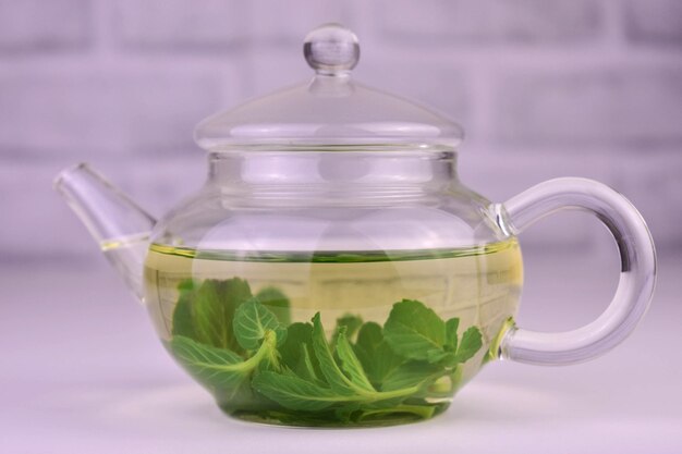 Teapot with mint tea on a white background