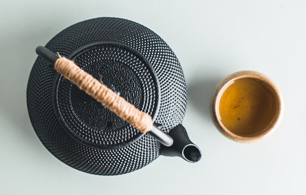 Photo teapot with tea on bright background