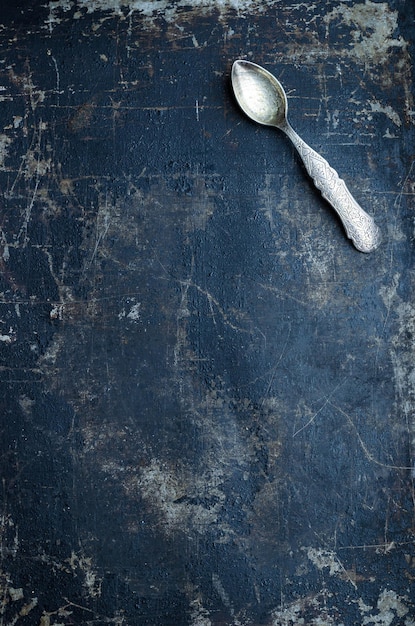 Teaspoon over dark grunge background top view