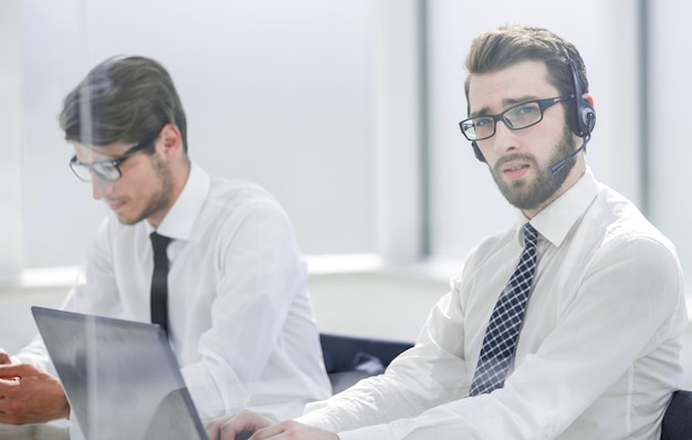 Tech support manager in headset consulting a client