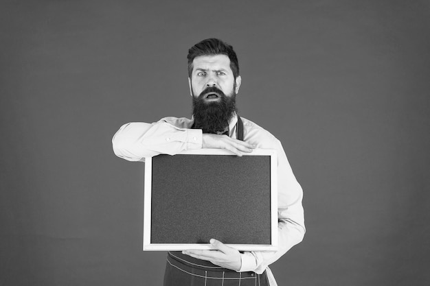 Technical issues Hipster bartender show blackboard copy space Hipster restaurant staff Hipster informing you Man bearded bartender or cook in apron hold blank chalkboard Price list concept