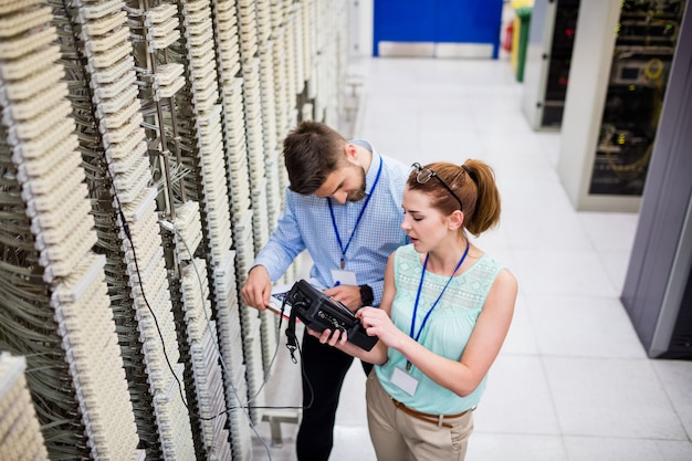 Foto technici die digitale kabelanalysator gebruiken