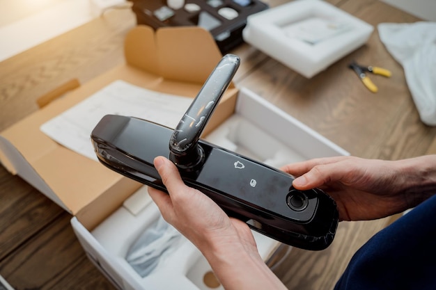 Photo a technician assembles and installs smart electronic door lock for house protection