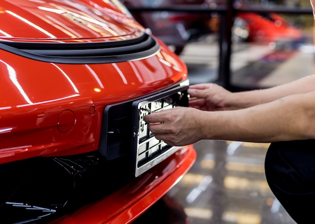 Technician changing car plate number in service center.