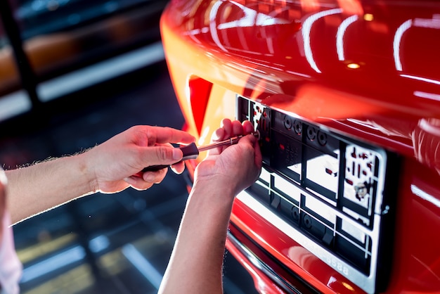 Technician changing car plate number in service center.