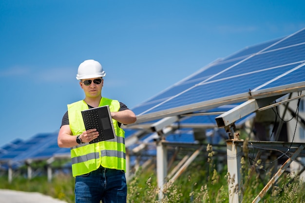 Technician checking efficiency of solar panel at solar power plant.