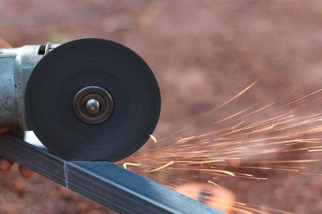 Photo technician cutting steel with tool in the workplace.