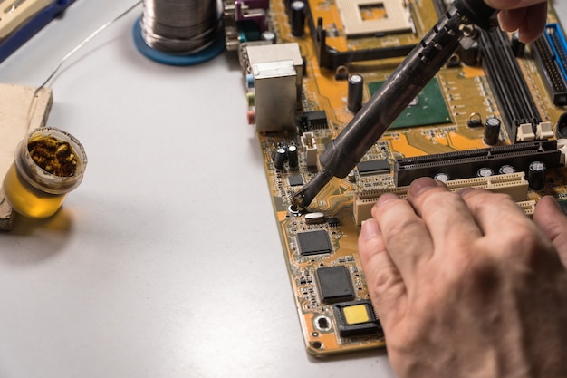 Technician electronic soldering and repairing computer chip