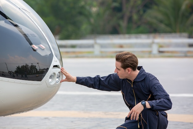 technician engineer standing in front of private helicopter in airport