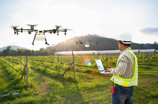 Foto l'agricoltore tecnico utilizza il drone agricolo di controllo del computer wifi per spruzzare fertilizzante sul campo di uva