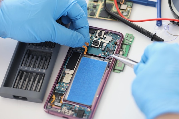 Technician fixing broken mobile phone set new battery and cover\
return old cellphone to life