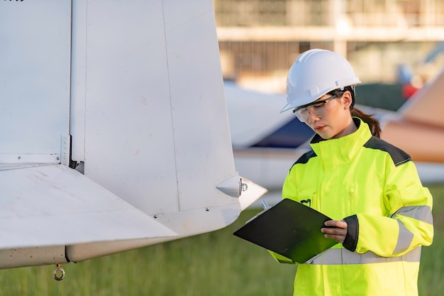 Technician fixing the engine of the airplanefemale aerospace\
engineering checking aircraft enginesasian mechanic maintenance\
inspects plane engine