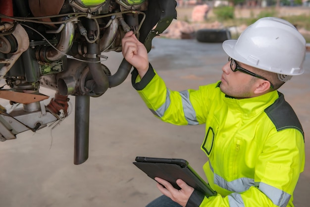 Technician fixing the engine of the airplanefemale aerospace\
engineering checking aircraft enginesasian mechanic maintenance\
inspects plane engine