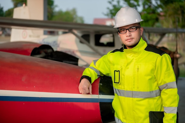 Technician fixing the engine of the airplanefemale aerospace\
engineering checking aircraft enginesasian mechanic maintenance\
inspects plane engine