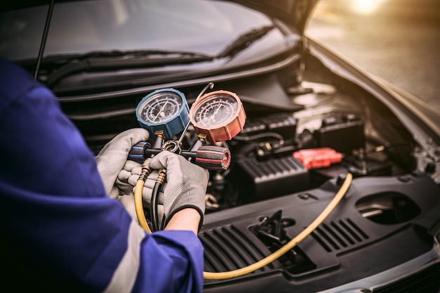 Photo technician hand and measuring manifold gauge checking car air conditioner