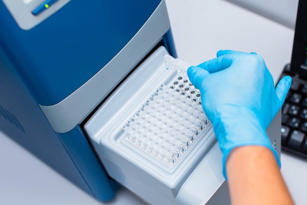 Technician inserts the test tubes into the dna analyzer