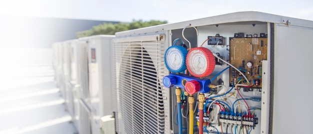 Technician inspecting air conditioner measuring equipment filling refrigerant