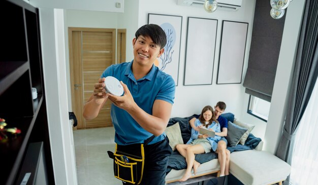 Photo technician installing fire safety detector in a modern apartment