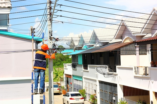 Technician internet service provider is checking fiber optic\
cables after install on electric pole