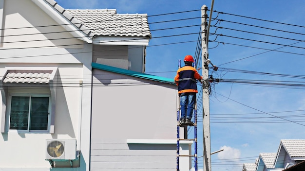 Il fornitore di servizi internet del tecnico sta controllando i cavi in fibra ottica dopo l'installazione sul palo elettrico