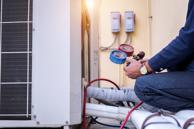 Technician is checking air conditioner ,measuring equipment filling air conditioners.