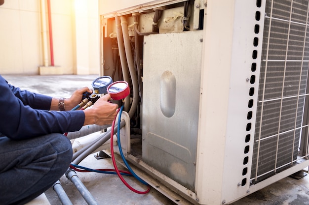 Technician is checking air conditioner measuring equipment for filling air conditioners.