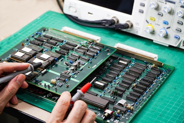 Technician is inspecting the circuit board by digital storage oscilloscope