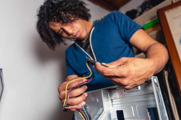 Technician man working on a computer case installing solid disk