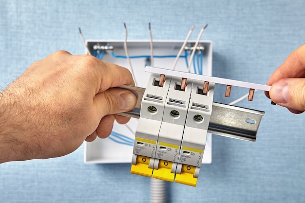 Technician mounts an electrical cabinet or switchboard.