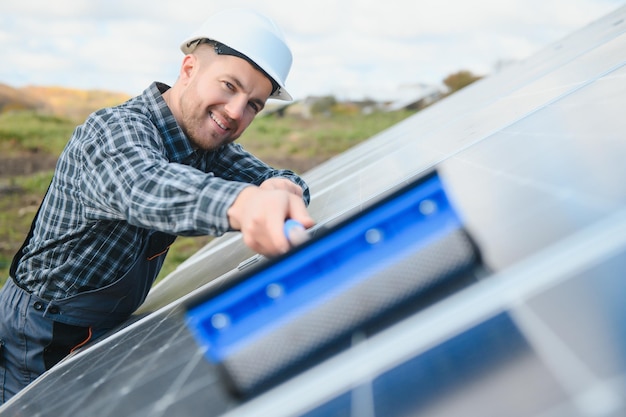 Tecnico che gestisce e pulisce i pannelli solari alla generazione di energia di un tecnico di centrali solari in uniforme industriale a livello di descrizione del lavoro a livello industriale