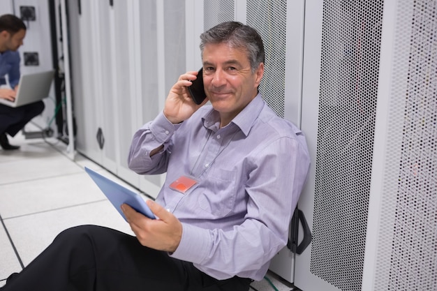 Technician phoning on the floor with digital tablet