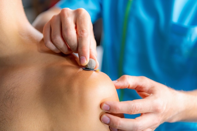 Technician placing markers on athletes shoulder preparing for 3d gait or movement analyses