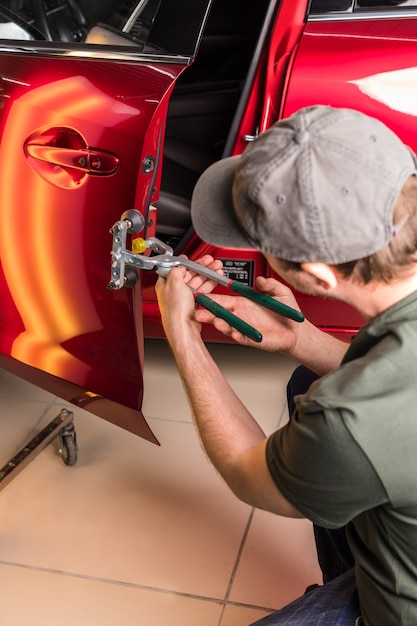 The technician removes dents on the car close up