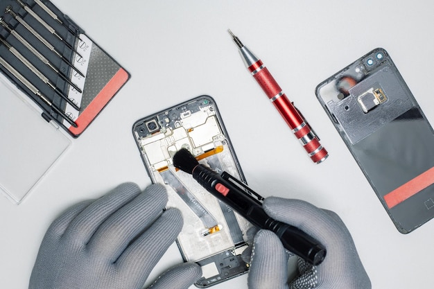 Technician repair and cleaning dirty smartphone in lab