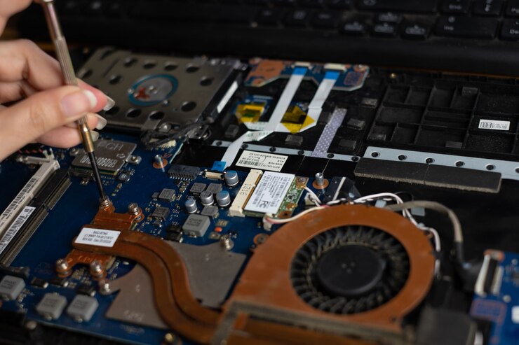 ドライバーで壊れたラップトップノートブックコンピューターを修理する技術者