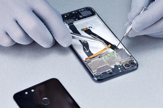 The technician repairing broken smartphone in the lab
